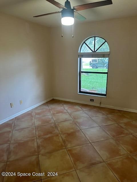 tiled empty room with ceiling fan