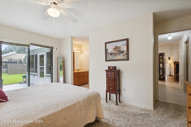 carpeted bedroom with ceiling fan, a textured ceiling, ensuite bath, and access to exterior