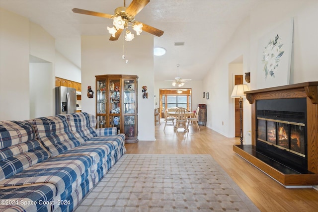 living room with high vaulted ceiling, light wood-type flooring, and ceiling fan