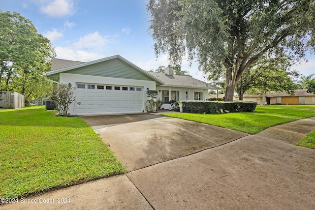 single story home with a garage and a front lawn