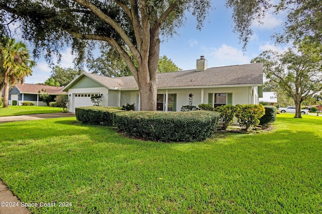 single story home featuring a garage and a front lawn