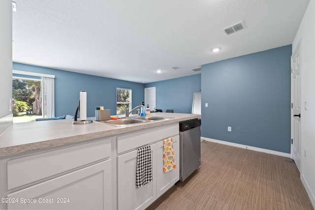 kitchen with white cabinetry, sink, stainless steel dishwasher, and plenty of natural light