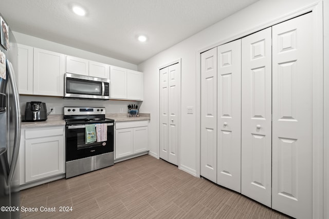 kitchen featuring stainless steel appliances and white cabinetry