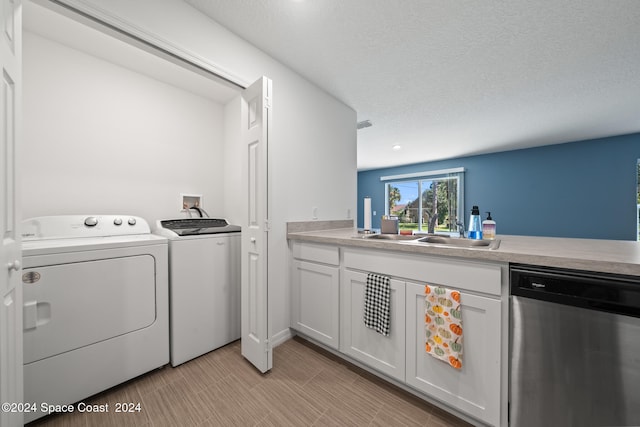 laundry area featuring washing machine and clothes dryer, sink, and a textured ceiling