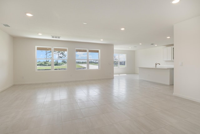 spare room featuring sink and light tile patterned floors