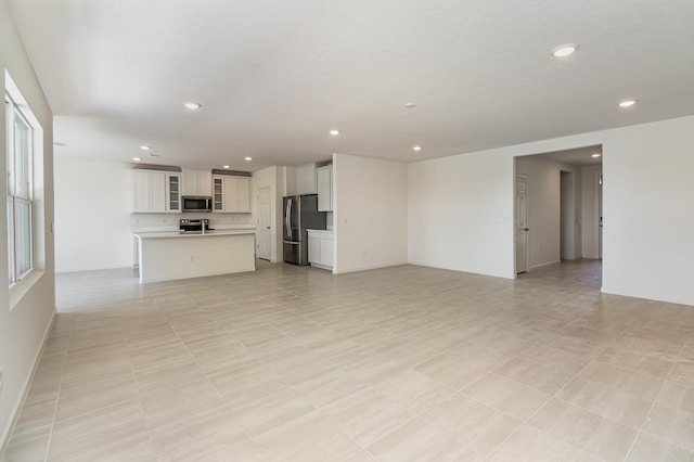 unfurnished living room featuring a textured ceiling and light tile patterned floors