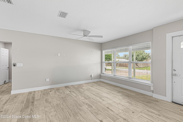 spare room featuring light hardwood / wood-style flooring, a textured ceiling, and ceiling fan