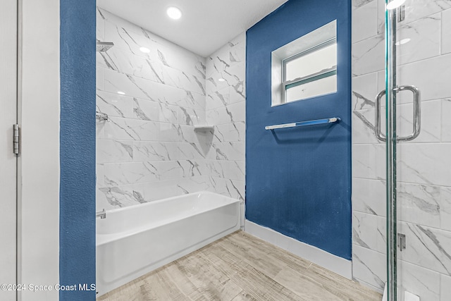 bathroom with independent shower and bath and hardwood / wood-style floors