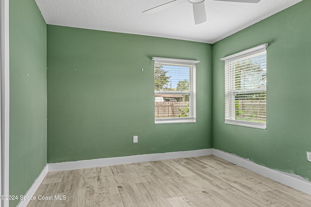 spare room with light hardwood / wood-style flooring, a textured ceiling, and ceiling fan