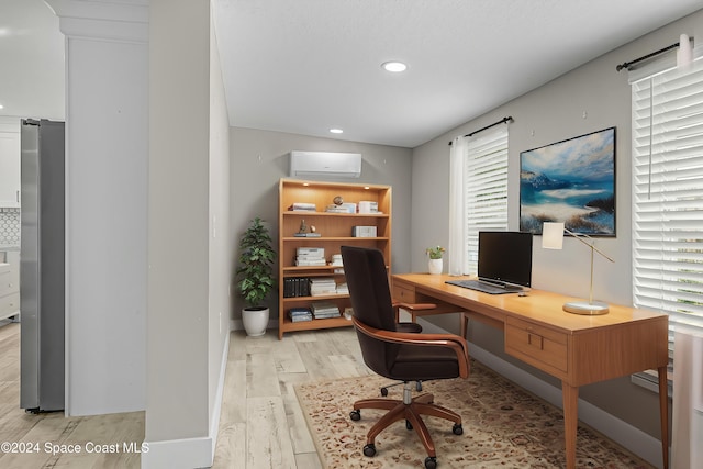 home office with a wall unit AC and light wood-type flooring