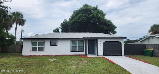 single story home featuring a garage and a front lawn