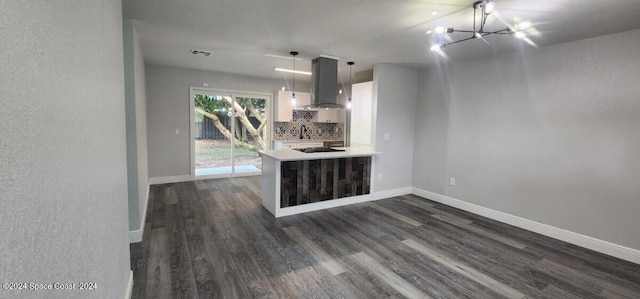 kitchen featuring white cabinetry, island range hood, kitchen peninsula, dark hardwood / wood-style flooring, and decorative light fixtures