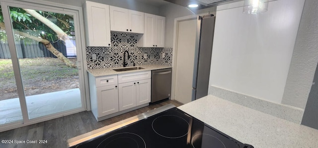 kitchen featuring stainless steel dishwasher, sink, dark hardwood / wood-style flooring, and white cabinets