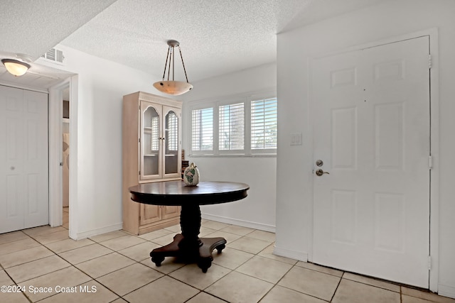 entryway featuring a textured ceiling and light tile patterned floors