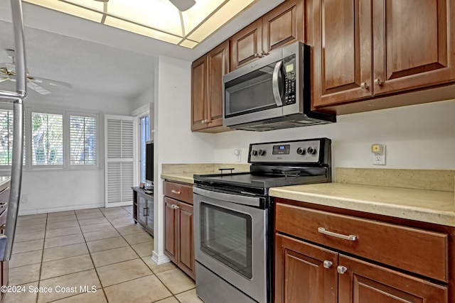 kitchen featuring stainless steel appliances, light tile patterned floors, and ceiling fan