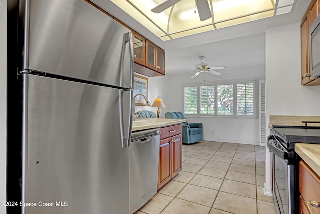 kitchen with ceiling fan, stainless steel appliances, and light tile patterned floors