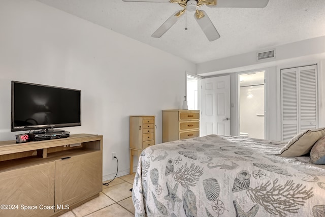 bedroom with light tile patterned floors, a textured ceiling, a closet, and ceiling fan