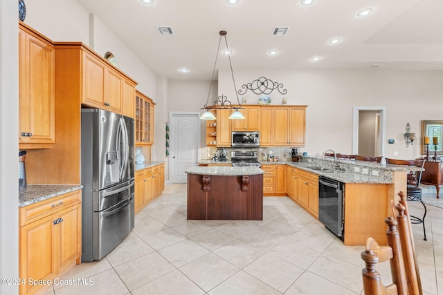 kitchen featuring sink, kitchen peninsula, stainless steel appliances, and a breakfast bar area