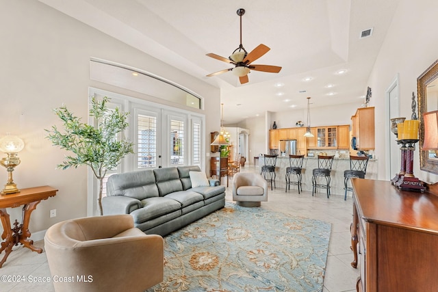 tiled living room with ceiling fan and french doors