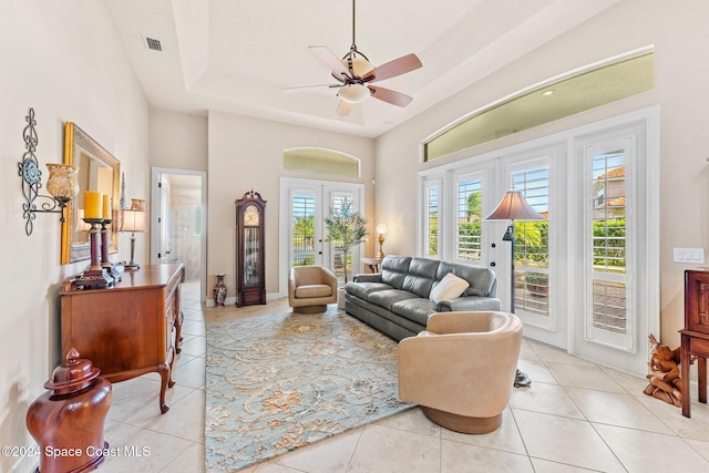 living room featuring french doors, a tray ceiling, plenty of natural light, and ceiling fan