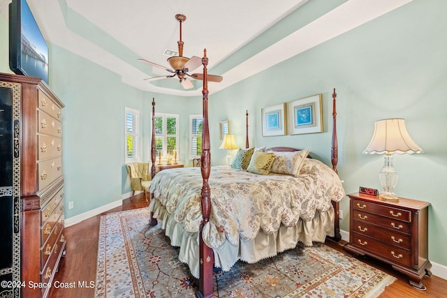 bedroom with dark hardwood / wood-style flooring and ceiling fan