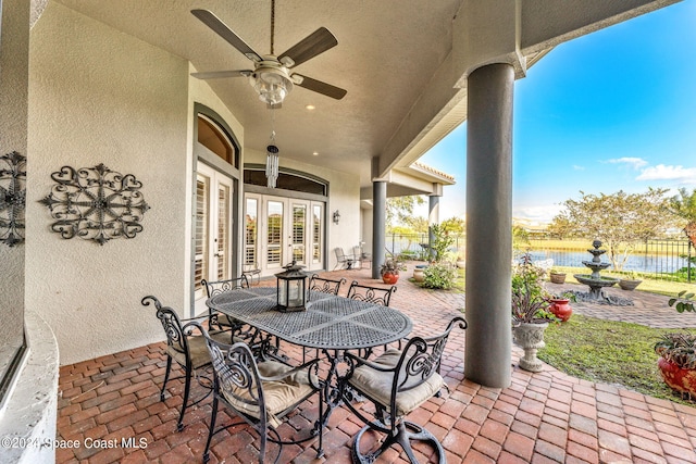 view of patio featuring ceiling fan, a water view, and french doors