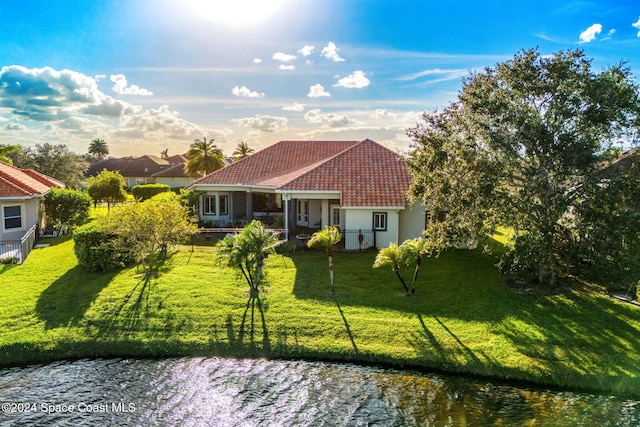 view of front of property with a water view and a front lawn