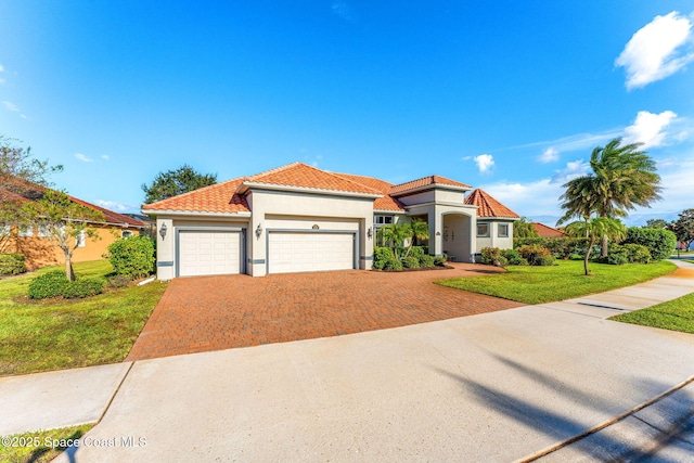 mediterranean / spanish-style house featuring a garage and a front yard