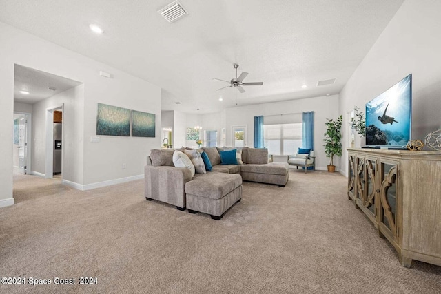 living room featuring ceiling fan with notable chandelier and light colored carpet