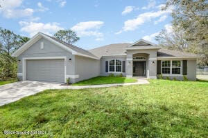 single story home featuring a garage and a front lawn