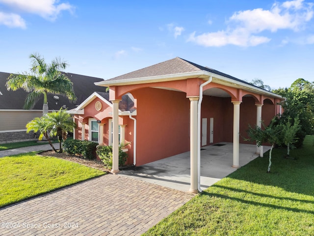 view of front of property featuring a front yard and a carport