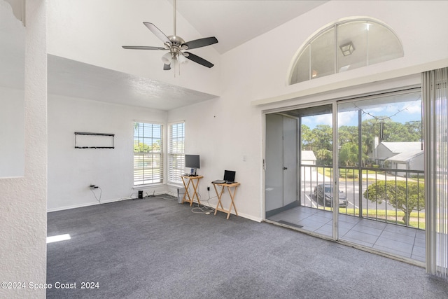 interior space featuring carpet flooring, ceiling fan, and high vaulted ceiling