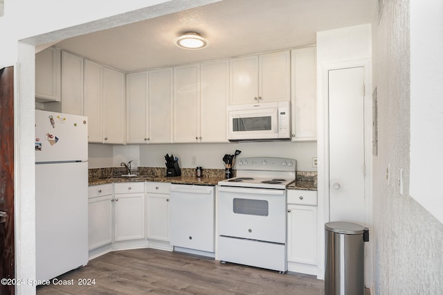 kitchen featuring dark stone countertops, white cabinets, white appliances, light wood-type flooring, and sink