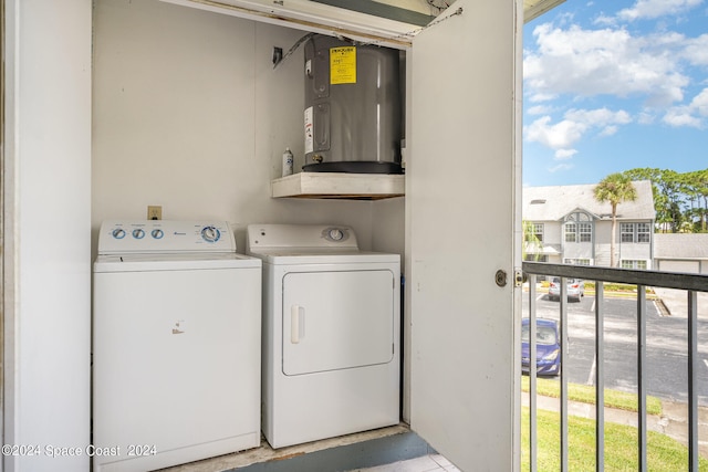 washroom featuring a healthy amount of sunlight, water heater, and independent washer and dryer