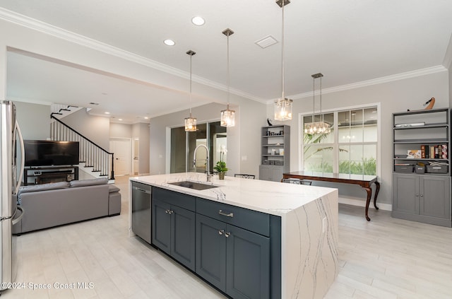 kitchen with a center island with sink, sink, light stone countertops, appliances with stainless steel finishes, and decorative light fixtures