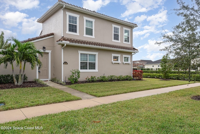 mediterranean / spanish-style home with a front yard