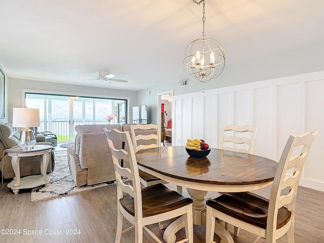 dining space featuring ceiling fan with notable chandelier and hardwood / wood-style floors