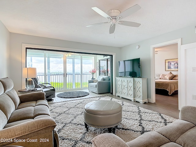 living room featuring a textured ceiling, a healthy amount of sunlight, ceiling fan, and hardwood / wood-style flooring