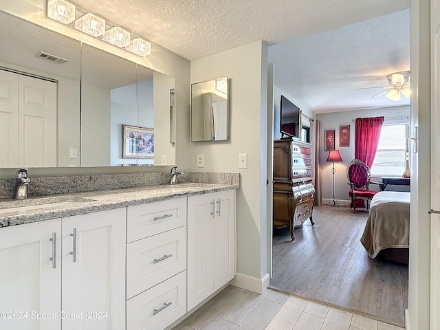 bathroom featuring a textured ceiling, vanity, ceiling fan, and hardwood / wood-style flooring