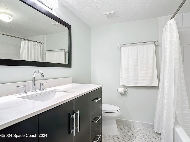 full bathroom with shower / bath combo with shower curtain, a textured ceiling, vanity, and toilet