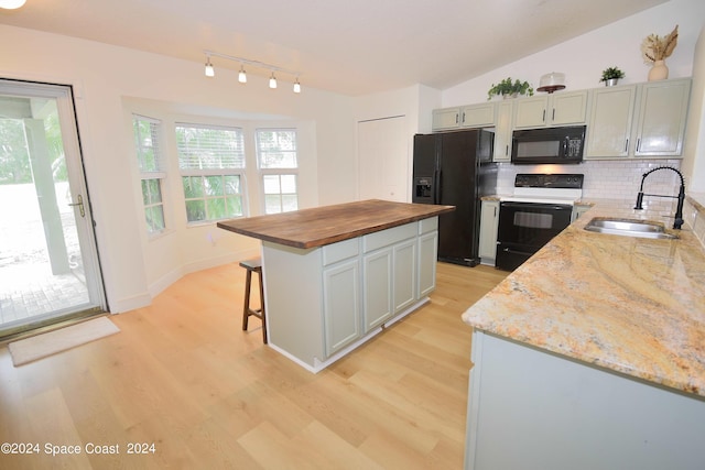 kitchen featuring sink, black appliances, a center island, and light hardwood / wood-style flooring