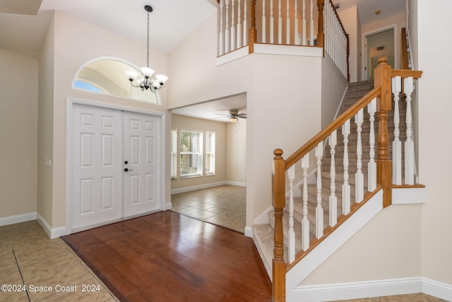 entryway featuring ceiling fan with notable chandelier, hardwood / wood-style floors, and high vaulted ceiling