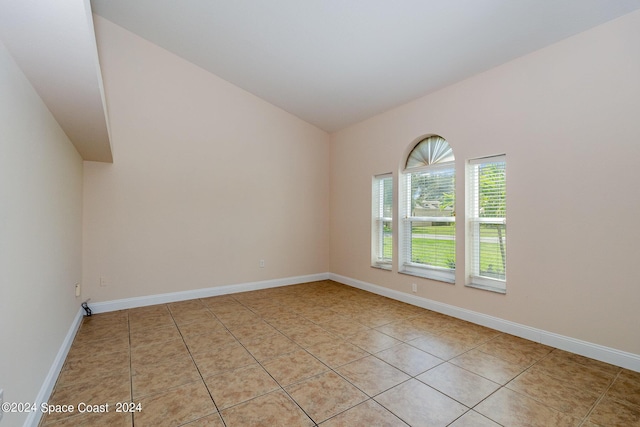 1290 Mercedes Dr, Merritt Island, FL 32952 - unfurnished room with lofted ceiling, light tile patterned flooring, and baseboards