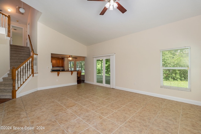 unfurnished living room with high vaulted ceiling, ceiling fan, and light tile patterned floors