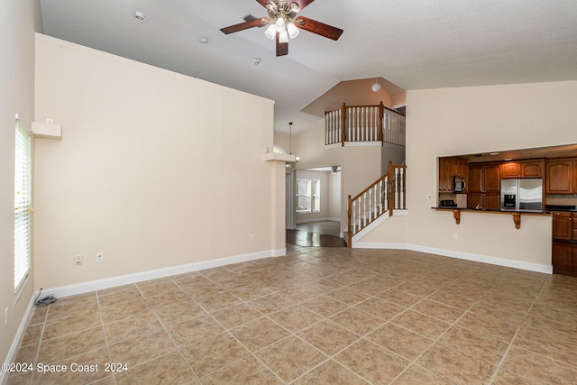 unfurnished living room with high vaulted ceiling, ceiling fan, and a wealth of natural light