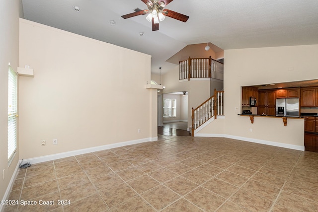 1290 Mercedes Dr, Merritt Island, FL 32952 - unfurnished living room with a ceiling fan, stairs, light tile patterned floors, high vaulted ceiling, and baseboards