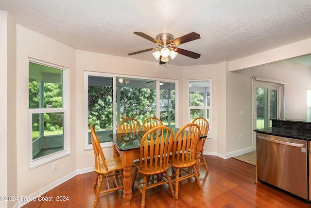 dining space featuring a textured ceiling, wood-type flooring, and plenty of natural light