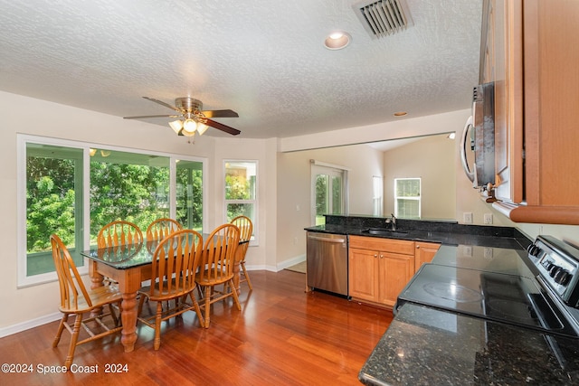 1290 Mercedes Dr, Merritt Island, FL 32952 - kitchen featuring stainless steel appliances, a sink, a textured ceiling, a ceiling fan, and a peninsula