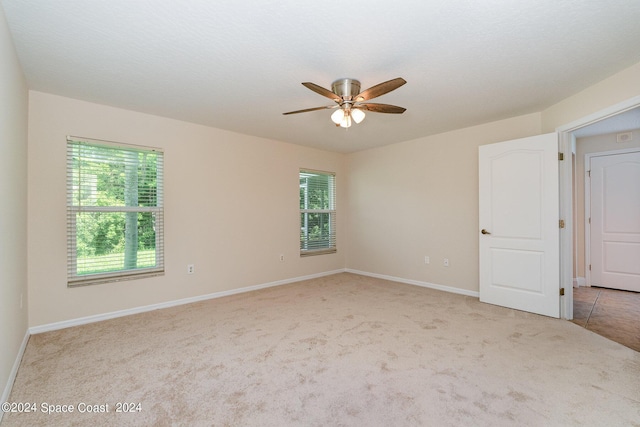 1290 Mercedes Dr, Merritt Island, FL 32952 - unfurnished room with light carpet, ceiling fan, plenty of natural light, and baseboards