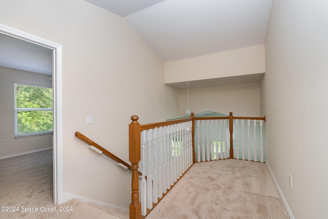 staircase featuring lofted ceiling and carpet floors